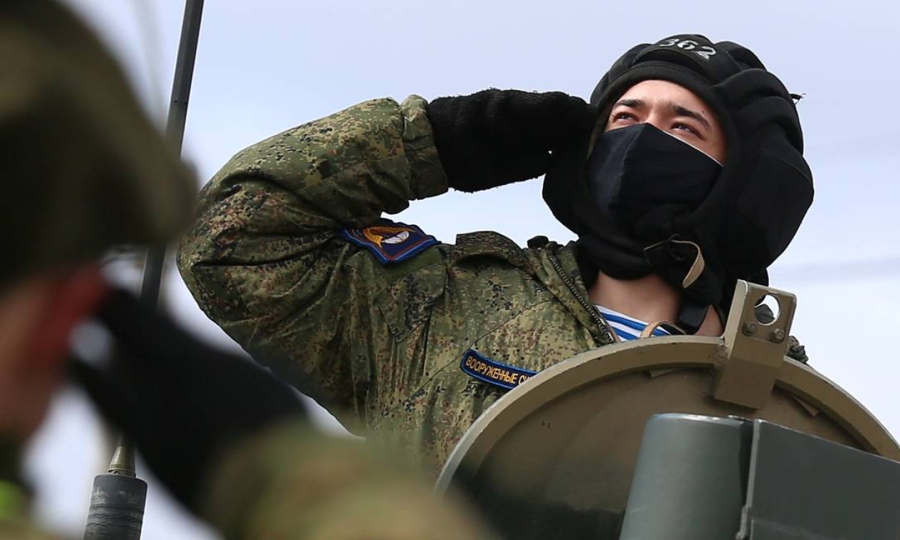 Soldado russo usa máscara protetora a bordo de um veículo militar durante o ensaio Foto: ALEXEI KOLCHIN / REUTERS