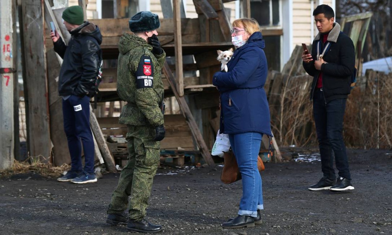 Soldado russo vestindo conversa com mulher que assiste ao ensaio militar Foto: ALEXEI KOLCHIN / REUTERS