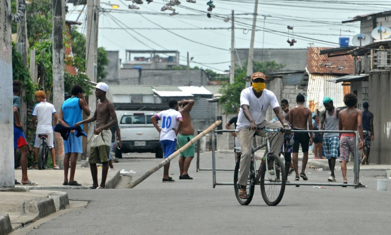 Futebol jogado na rua continua fazendo parte da rotina do bairro onde a fome é mata Foto: JOSE SANCHEZ LINDAO / AFP