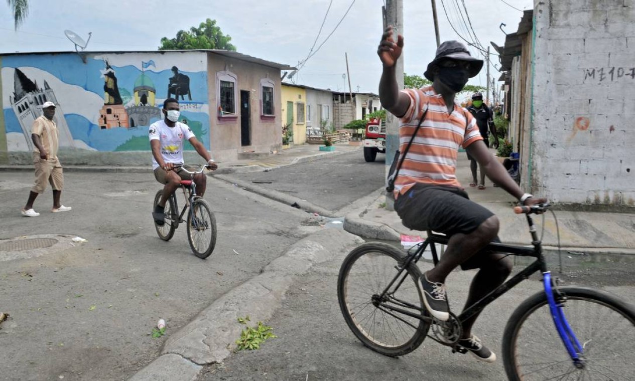 Moradores andam de bicicleta por uma rua do bairro da Nigéria Foto: JOSE SANCHEZ LINDAO / AFP