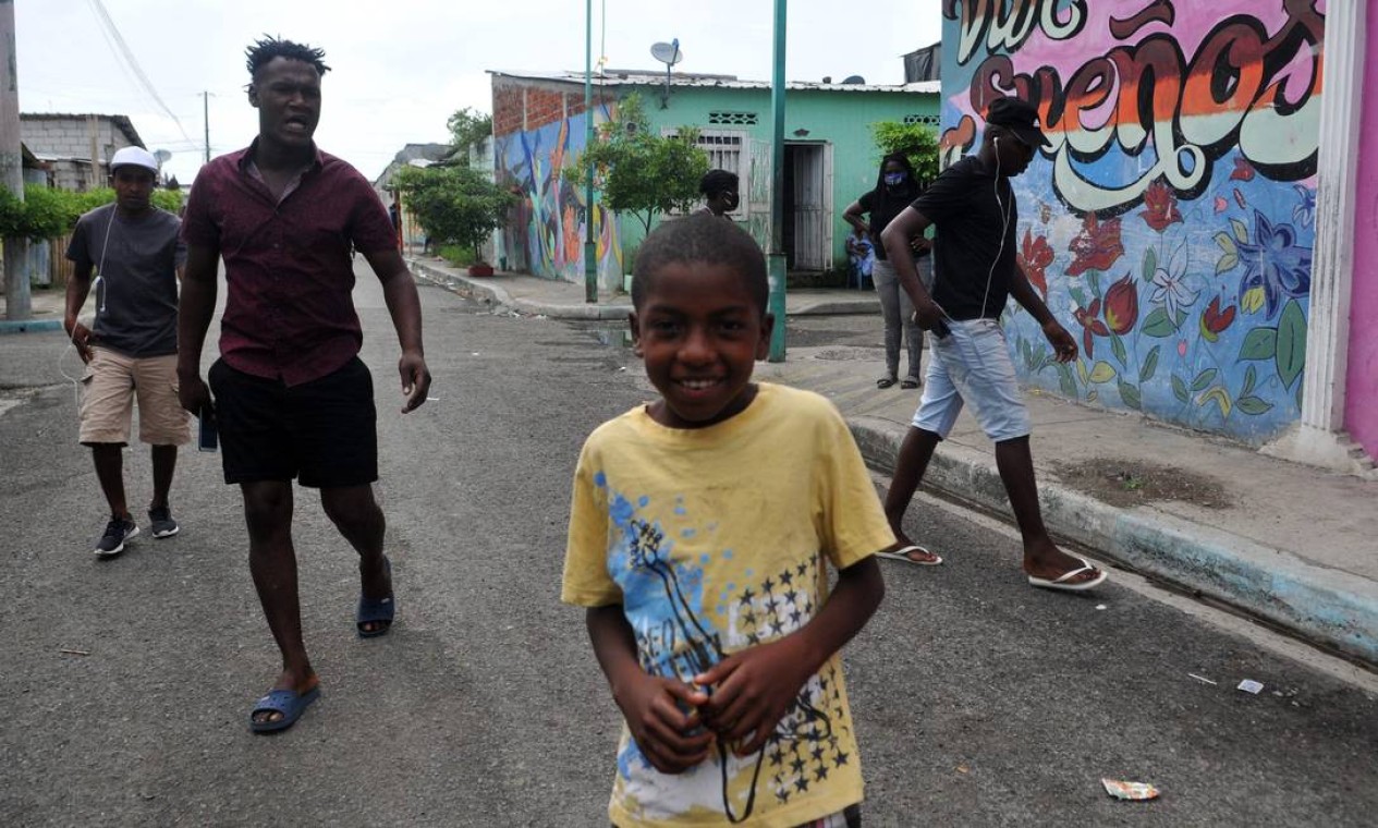 Os moradores caminham ao longo de uma rua do bairro da Nigéria, na seção Isla Trinitaria, no sul de Guayaquil Foto: JOSE SANCHEZ LINDAO / AFP