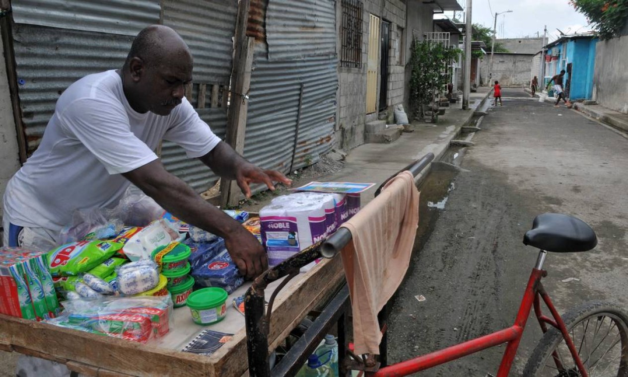 Vendedor ambulante organiza os produtos em do assentamento Nigéria Foto: JOSE SANCHEZ LINDAO / AFP
