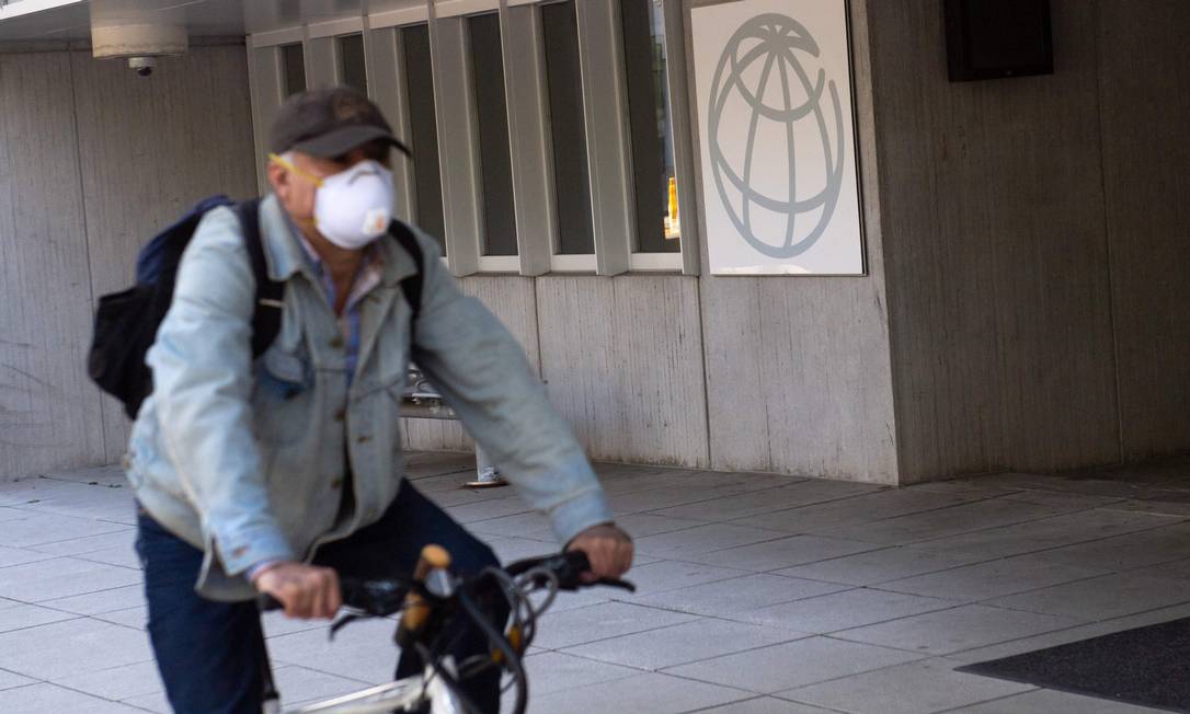 Um homem usando máscara de proteção passa em frente à sede do Banco Mundial Foto: Saul Loeb / AFP