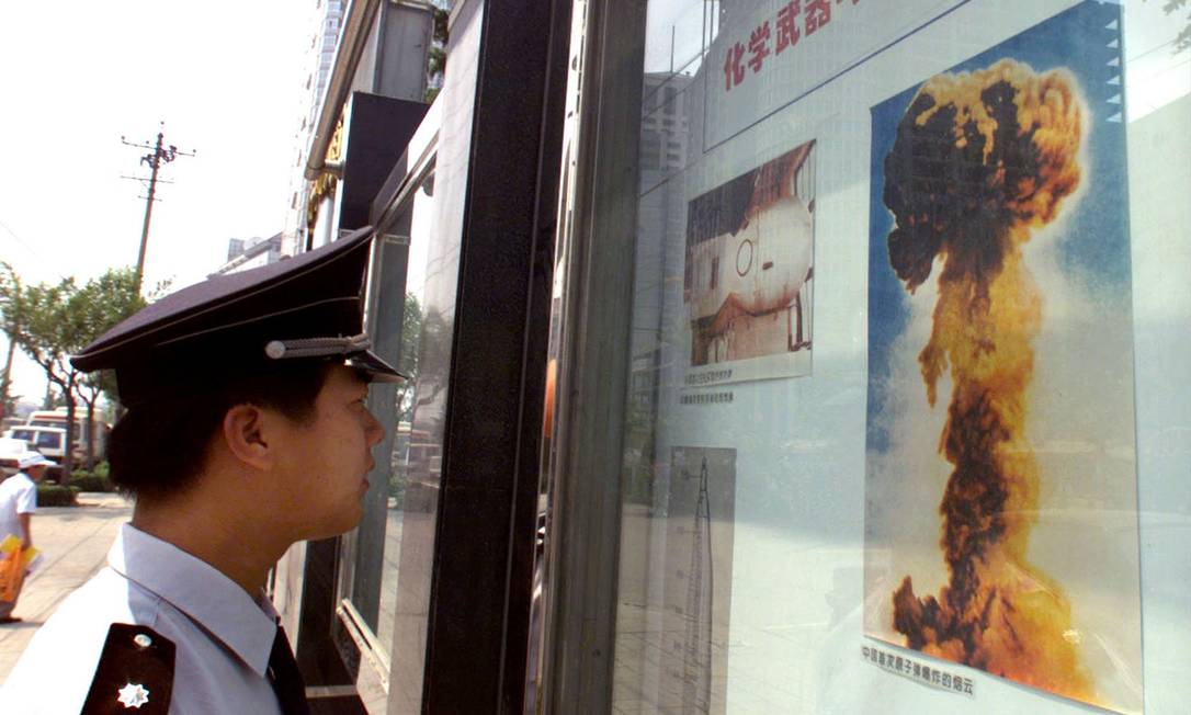 Homem observa imagem de detonação de bomba nuclear chinesa em um quadro informativo no centro de Pequim Foto: Andrew Wong / Reuters