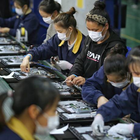 Após paralisação, atividades industriais da China foram retomadas seguindo protocolos de proteção individual Foto: China Daily / Reuters