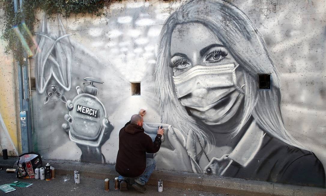 O grafiteiro David &#034;S.I.D.&#034; Perez retoca sua pintura em homenagem aos profissionais de saúde em Gland, na Suíça Foto: Denis Balibouse / Reuters