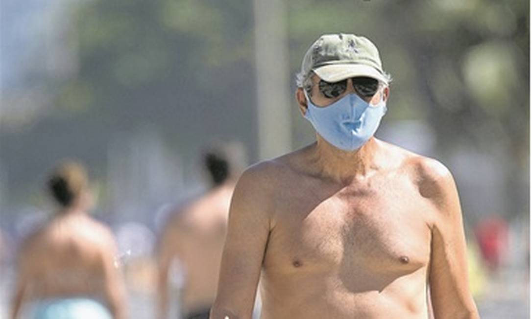 Homem caminha com máscara no calçadão de Copacabana: o uso do item é exigido em locais públicos Foto: Ana Branco / Agência O Globo