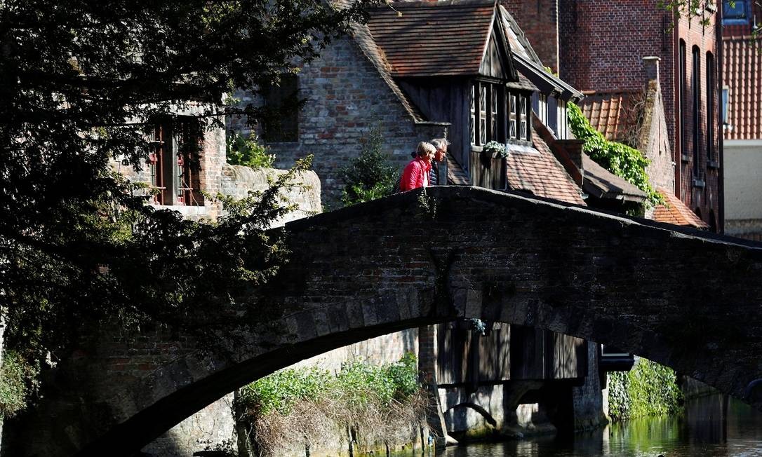 Um casal atravessa uma ponte no centro histórico de Bruges Foto: Francois Lenoir / Reuters