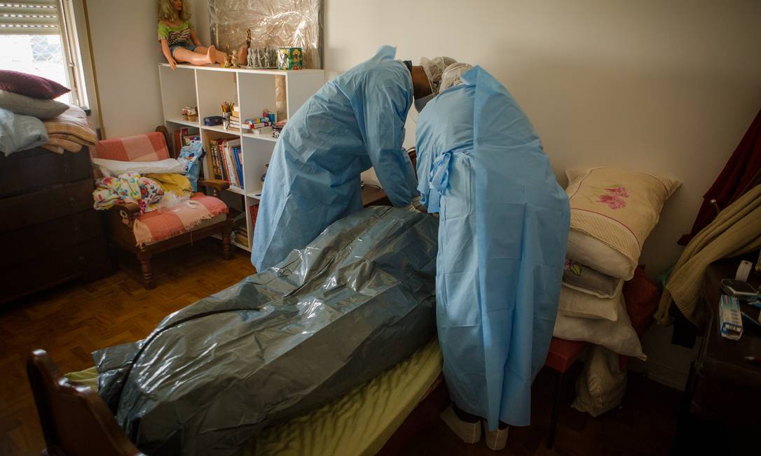 Socorristas do Samu preparam cadáver de mulher idosa que morreu com suspeita de estar contaminada pelo novo coronavírus Foto: Yan Boechat