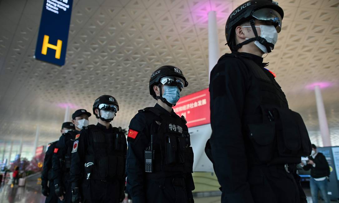 Policiais chineses utilizando máscaras Foto: Hector Retamal / AFP