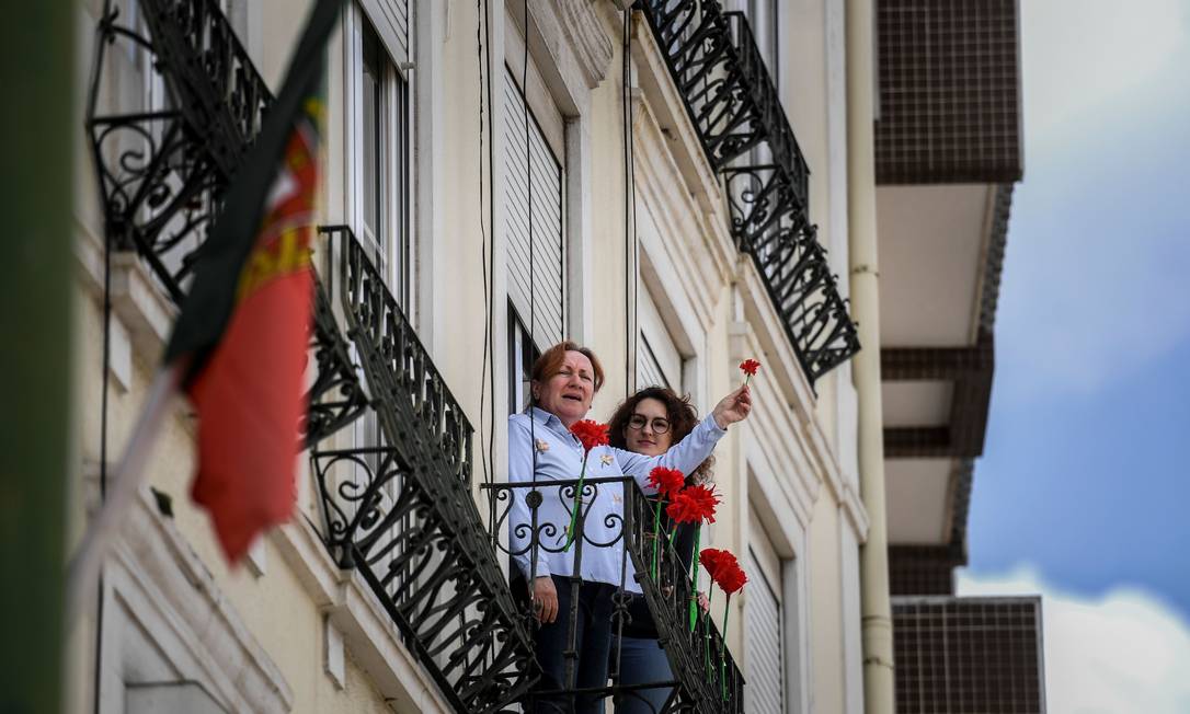 Cidadãos portugueses celebram o 46º aniversário da Revolução dos Cravos de suas janelas durante a pandemia do novo coronavírus Foto: Patricia de Melo Moreira / AFP