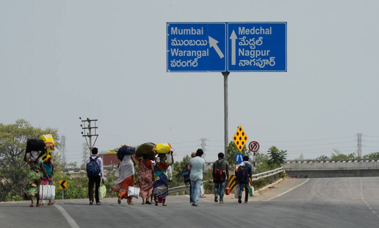 Trabalhadores migrantes se andam ao longo da rodovia nacional 44, nos arredores de Hyderabad , para voltar para o estado indiano de Maharashtra Foto: NOAH SEELAM / AFP