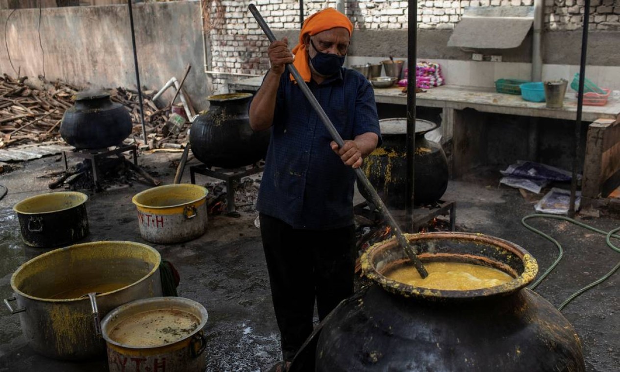 Um cozinheiro prepara refeição que será distribuída entre trabalhadores migrantes e moradores de rua por voluntários da Sociedade da Cruz Vermelha Indiana, em Faridabad, Índia Foto: DANISH SIDDIQUI / REUTERS