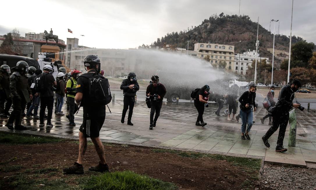Polícia dispara canhões d'água contra manifestantes durante protesto em Santiago no dia 27 de abril Foto: JAVIER TORRES / AFP