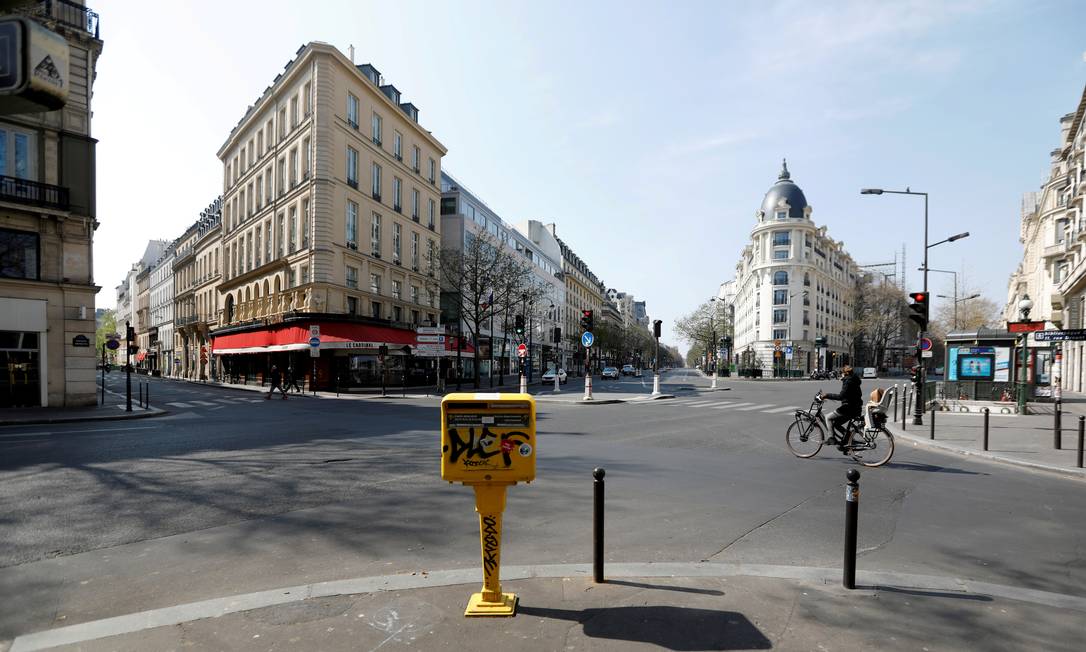 Um ciclista passa pelas vias desertas de Grands Boulevards, em Paris, próximo a um bloqueio instalado para tentar diminuir o avanço da Covid-19 na França Foto: Charles Platiau / Reuters