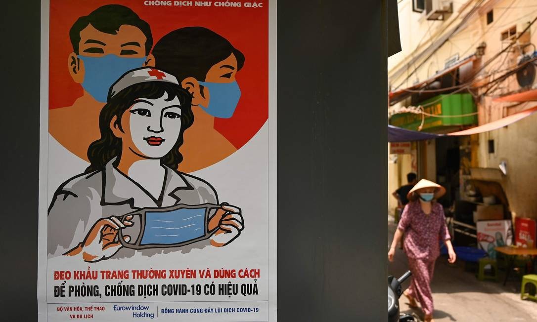 Propaganda do governo vietnamita para o uso obrigatório de máscaras no país Foto: MANAN VATSYAYANA / AFP