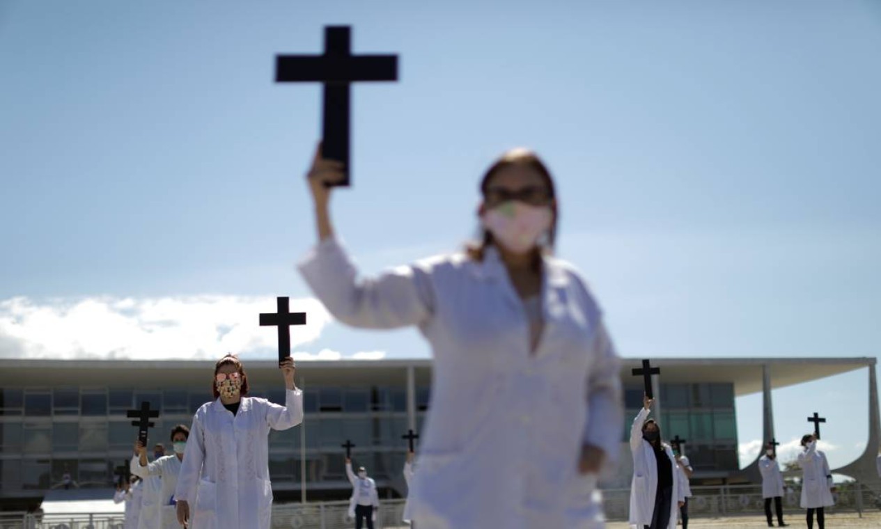 Enfermeiras usam máscaras protetoras e seguram cruzes durante um protesto e homenagem aos trabalhadores da saúde no Dia do Trabalho, em meio à disseminação do novo coronavírus, em Brasília Foto: UESLEI MARCELINO / REUTERS