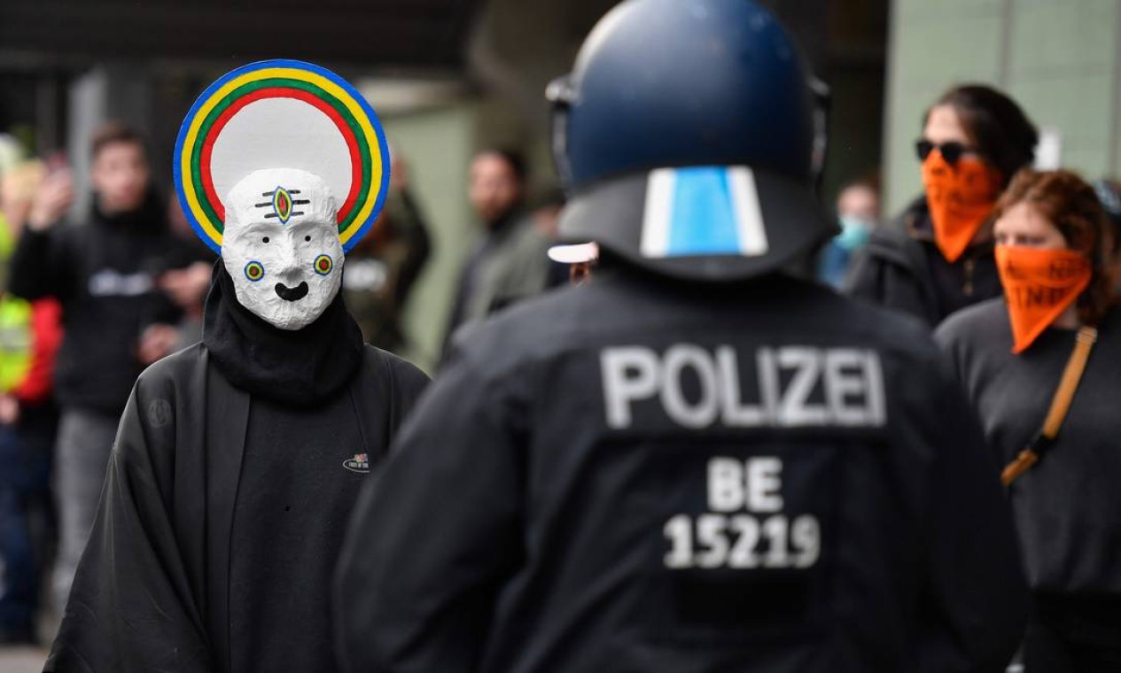 Manifestante de máscara enfrenta a polícia no distrito de Kreuzberg, em Berlim, durante os protestos do primeiro de maio em meio ao surto de Covid-19 Foto: JOHN MACDOUGALL / AFP