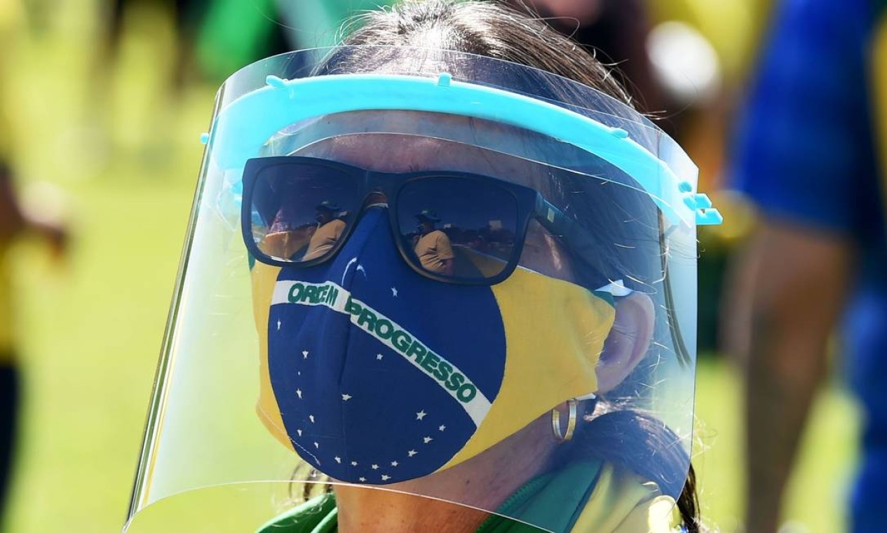 Apoiadora vestida com as cores verde e amarelo e usando máscaras de proteção participa de manifestação de apoio ao presidente Jair Bolsonaro, em Brasília Foto: EVARISTO SA / AFP