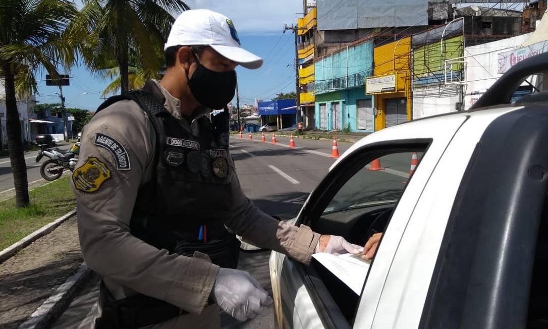 Policial verifica autorização de circulação em blitz em São Luiz; ilha maranhense adotou bloqueio total de acessos nesta terça-feira Foto: Albani Ramos