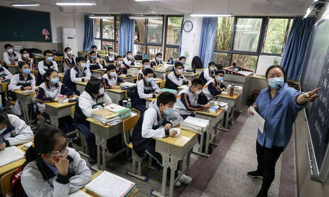 Turma do último ano do ensino médio acompanha aula em Wuhan Foto: STR / AFP