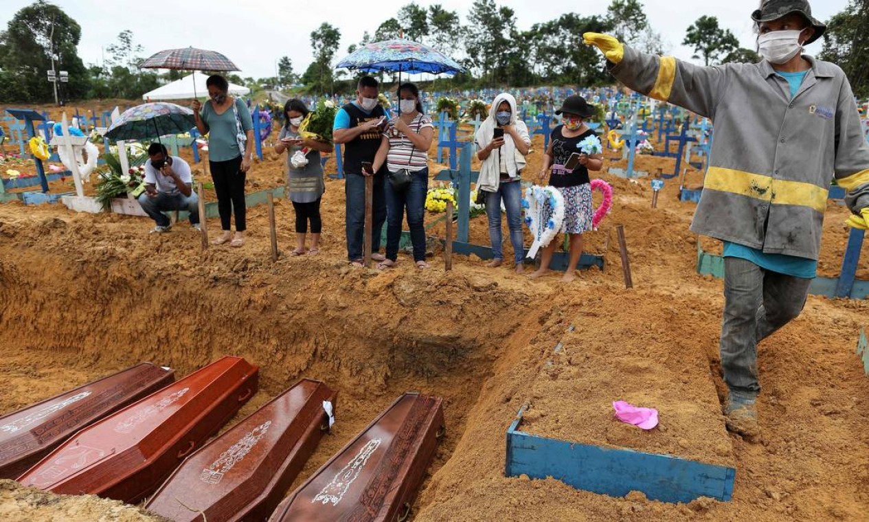 Parentes de vítimas da Covid-19 acompanham sepultamento dos seus entes em uma vala comum no cemitério de Nossa Senhora. Foto: MICHAEL DANTAS / AFP