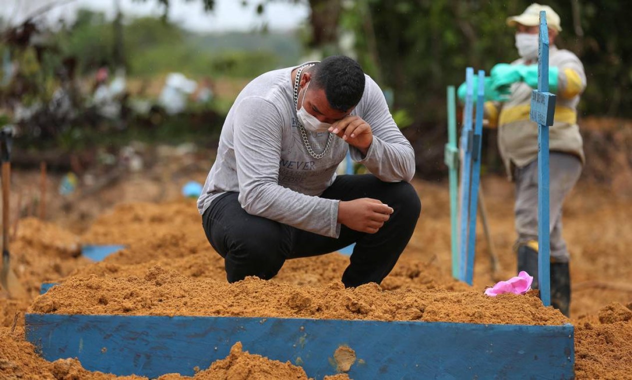 Homem lamenta a morte de sua avó, Enedina Soares, 71, vítima de coronavírus, no cemitério de Nossa Senhora. Manaus tem protagonizado algumas das cenas mais impactantes da pandemia no Brasil Foto: MICHAEL DANTAS / AFP