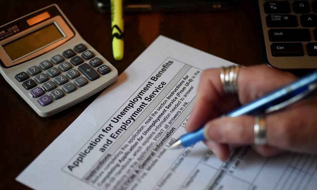 Americana preenche formulário para receber seguro-desemprego em Arlington, Virginia. Foto: OLIVIER DOULIERY / AFP
