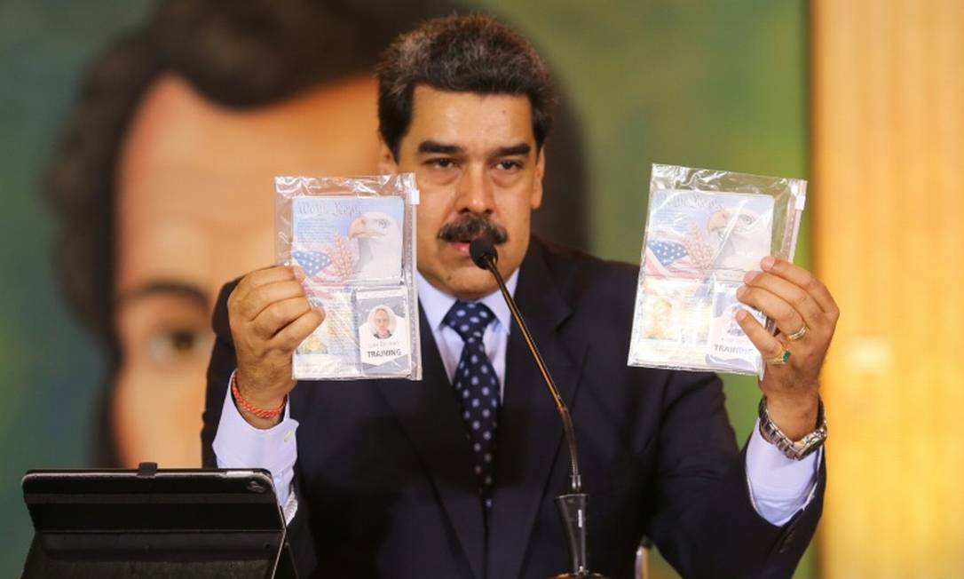 O presidente venezuelano, Nicolás Maduro, mostra os passaprotes dos dois americanos presos pelas forças de segurança da Venezuela Foto: AFP / Marcelo Garcia