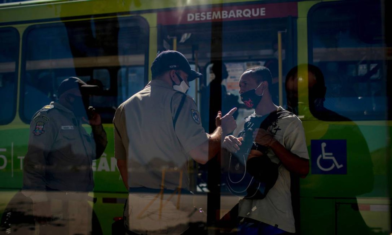 Guardas municipais conversam com um homem perguntando por que ele estava na rua durante o primeiro dia de confinamento devido ao coronavírus Foto: MAURO PIMENTEL / AFP