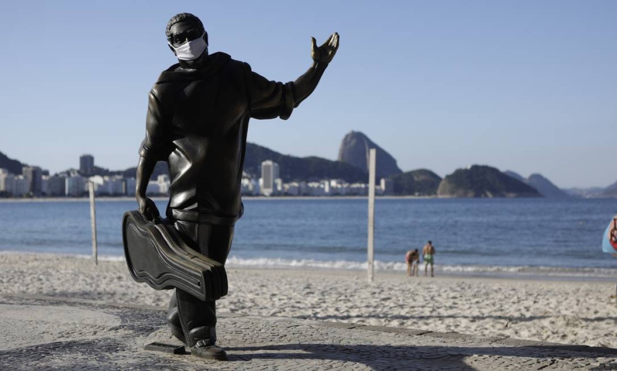 Estátua do compositor baiano Dorival Caymmi também ganhou máscara, em Copacabana Foto: LUIZA MORAES / Agência O Globo