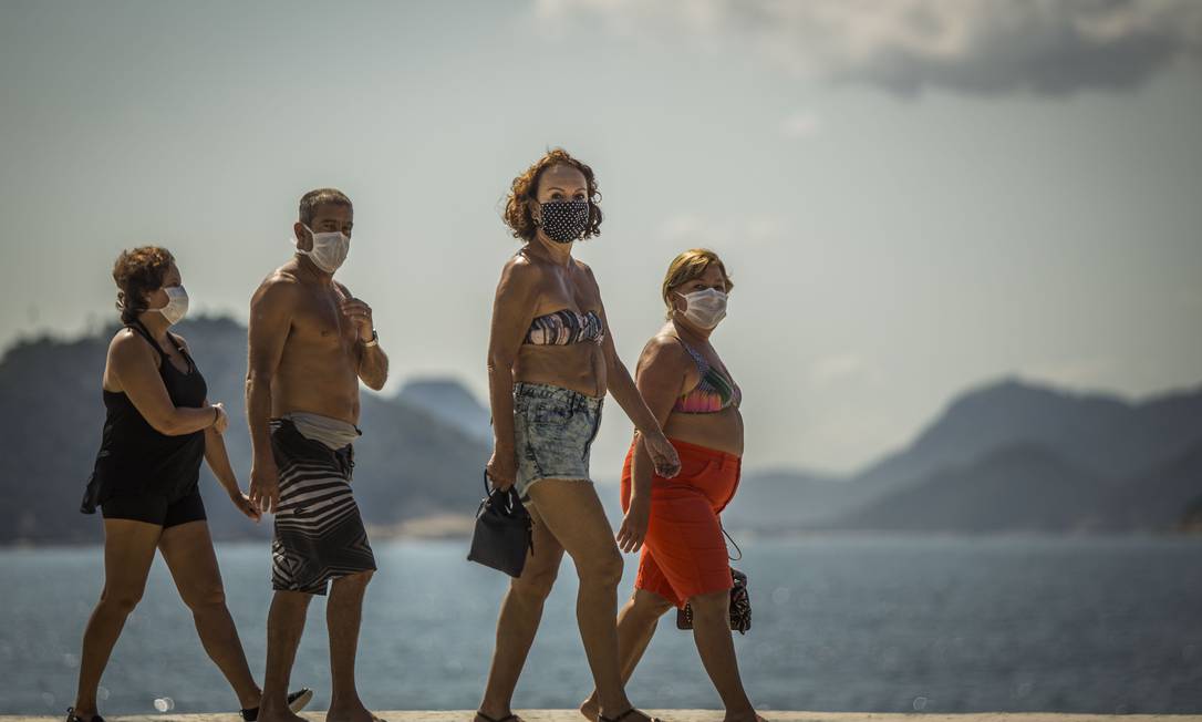 Pedestres de máscaras caminham pela Zona Sul da cidade Foto: Guito Moreto / Agência O Globo