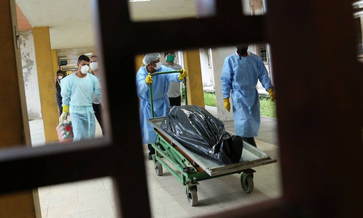 Uma equipe mortuária transporta o corpo de uma vítima da COVID-19 no hospital regional em Iquitos, maior cidade da Amazônia peruana, no Peru Foto: CESAR VONBANCELS / AFP