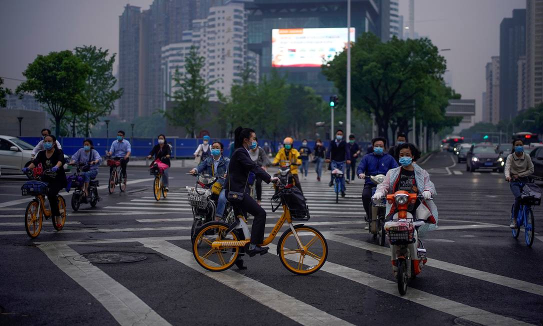 Ciclistas usam máscaras protetoras e luvas em Wuhan, cidade chinesa mais atingida pelo novo coronavírus Foto: ALY SONG / REUTERS