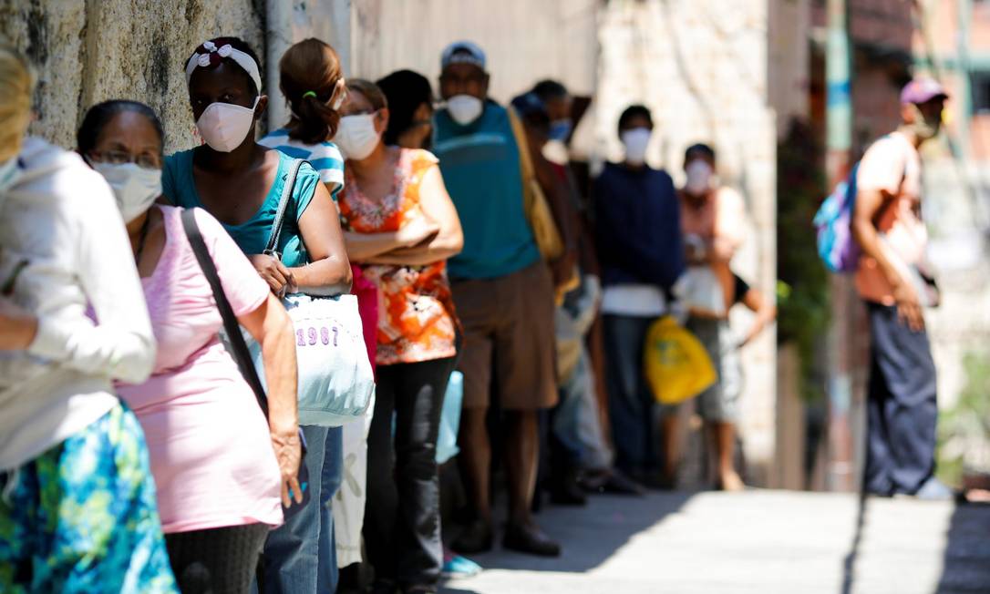 Pessoas fazem fila para receber doação de alimentos na favela de Carapita, em Caracas Foto: MANAURE QUINTERO / REUTERS