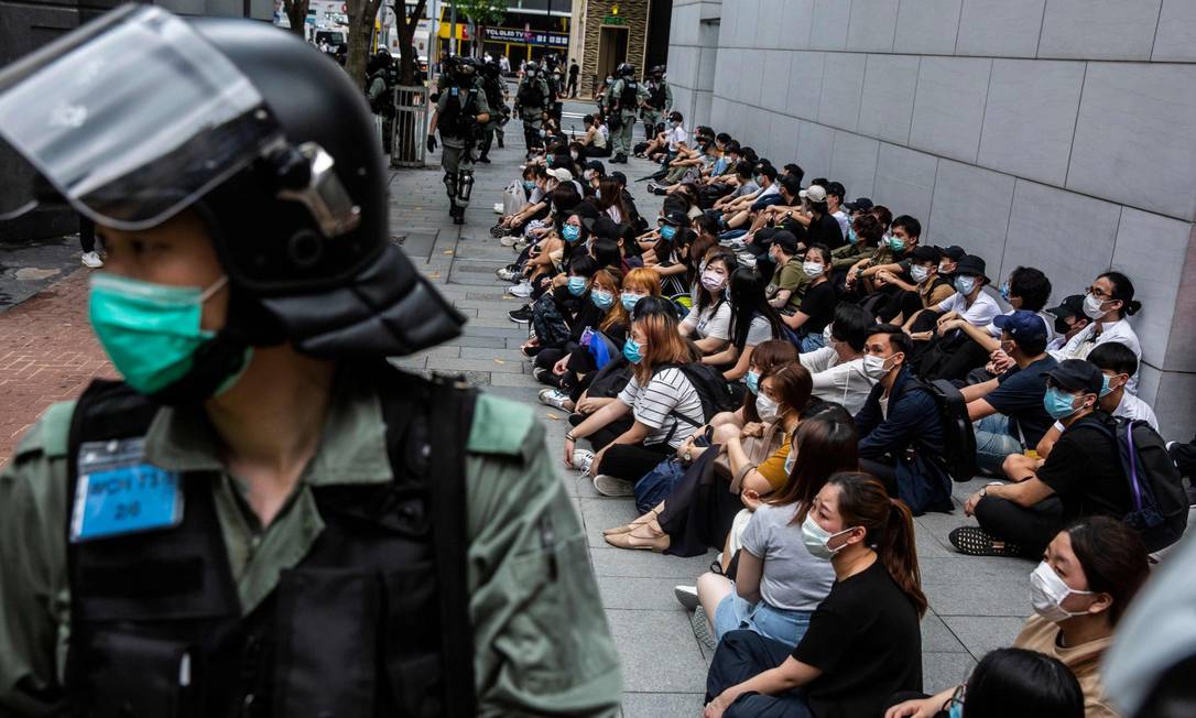 Após serem detidos, manifestantes aguardam sentados para serem levados para a delegacia Foto: ISAAC LAWRENCE / AFP