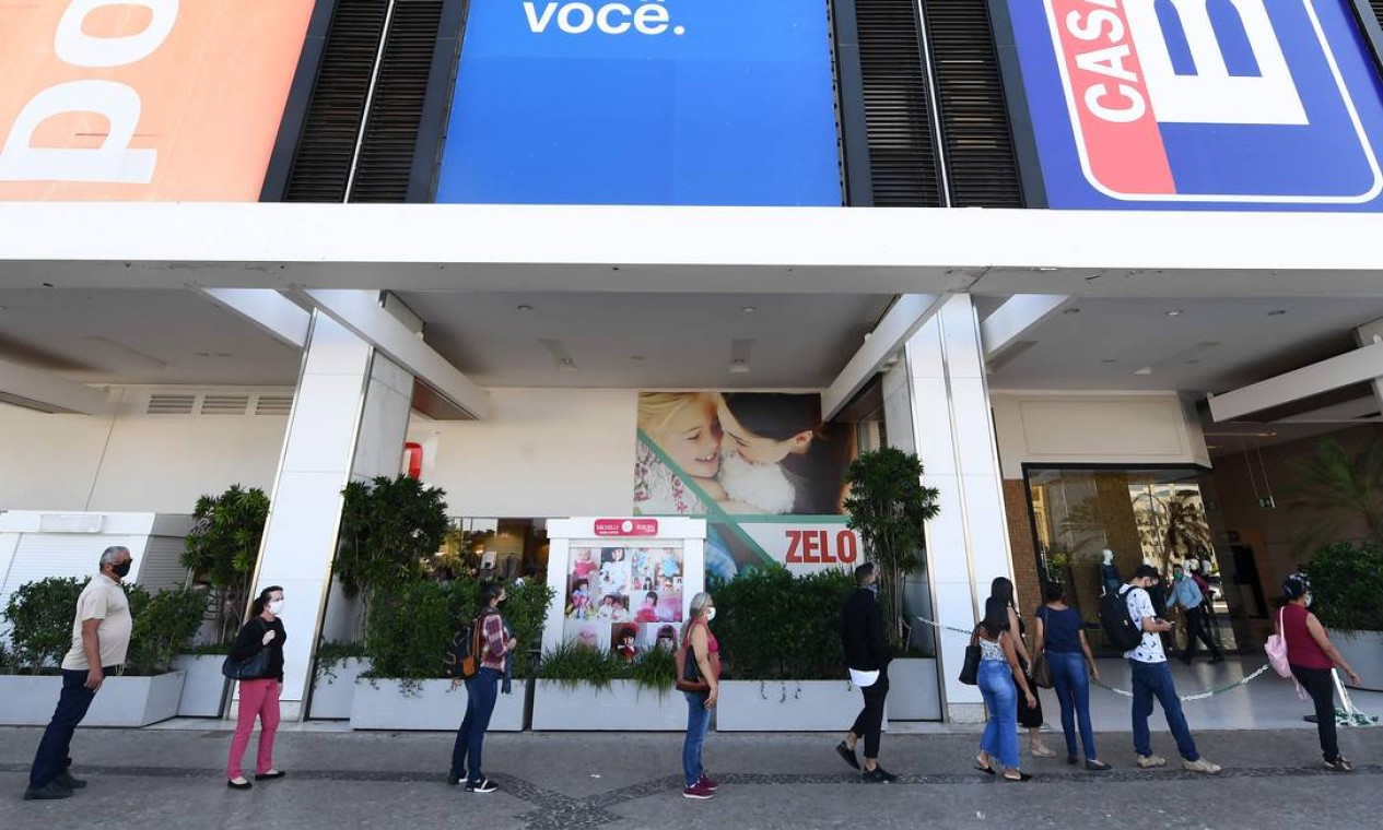 Pessoas esperam na fila para verificar a temperatura corporal antes de entrar em um shopping em Brasília, nesta quarta-feira, primeiro dia de reabertura de negócios na cidade, em meio à pandemia de Covid-19 Foto: EVARISTO SA / AFP