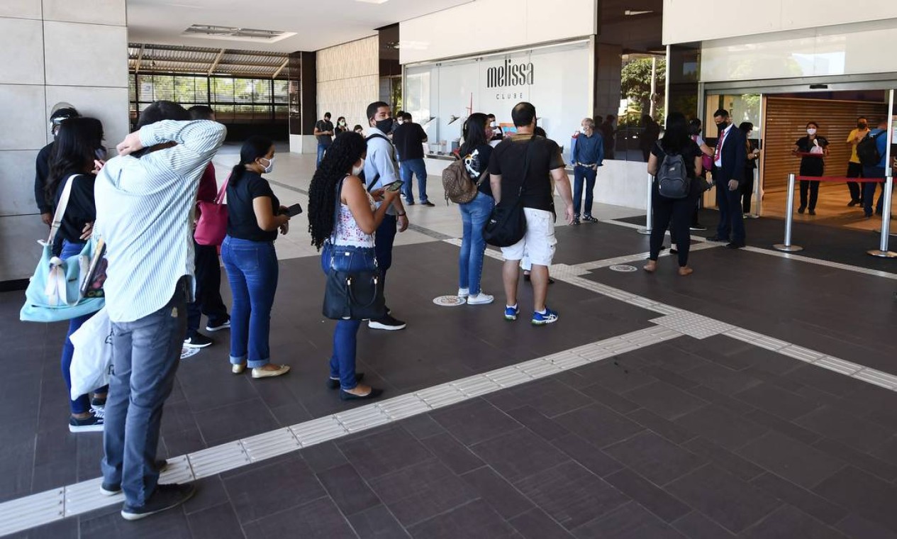 As pessoas esperam na fila para verificar a temperatura corporal antes de entrar em um shopping em Brasília Foto: EVARISTO SA / AFP