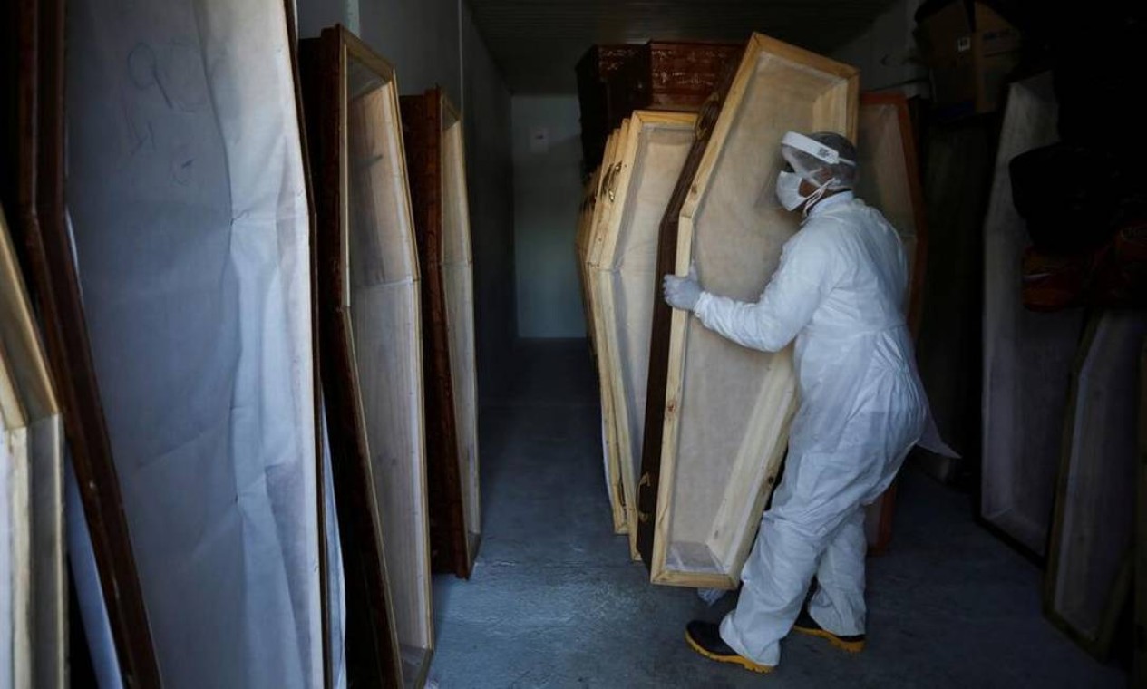 Funcionário de um serviço funerário de Manaus prepara caixões em meio ao surto de coronavírus Foto: Bruno Kelly / REUTERS