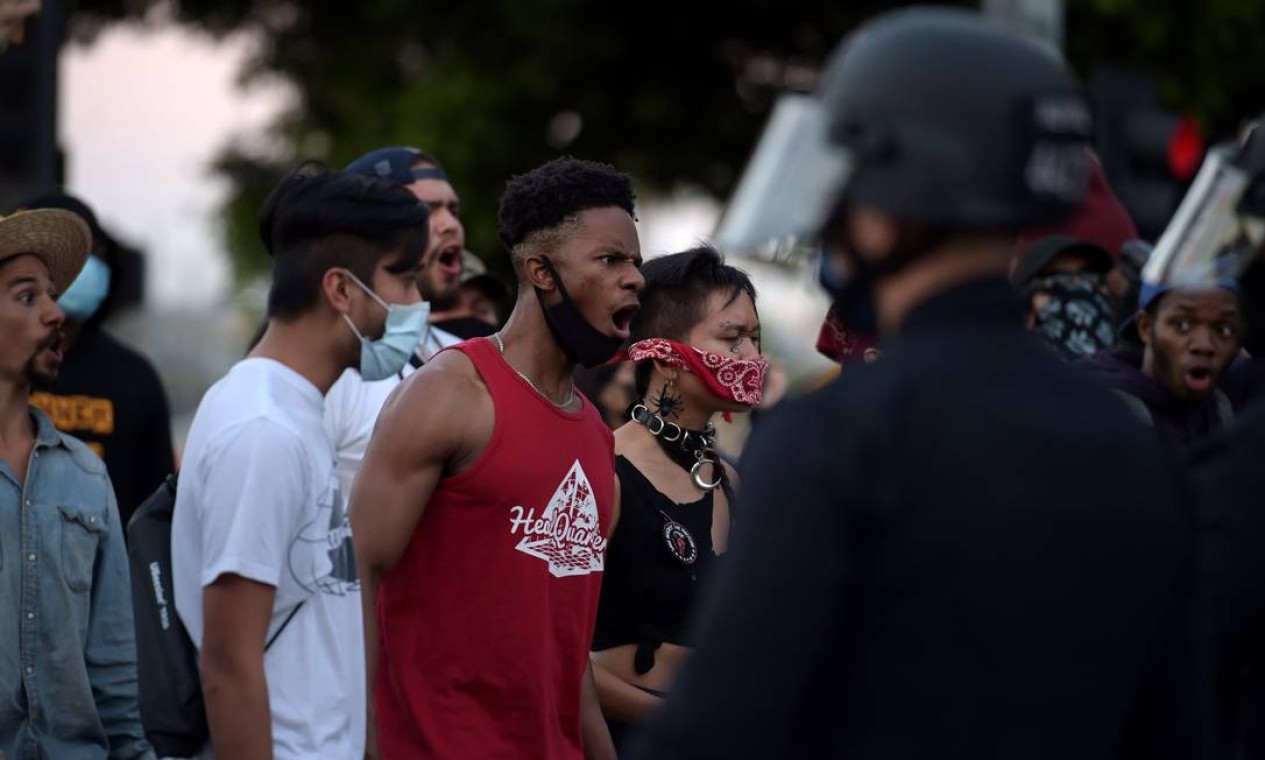 Manifestantes reagem na frente da polícia quando se reúnem no centro de Los Angeles, Califórnia. A barbárie da polícia de Minessota uniu minorias dos EUA em protestos na quarta-feira passada Foto: AGUSTIN PAULLIER / AFP