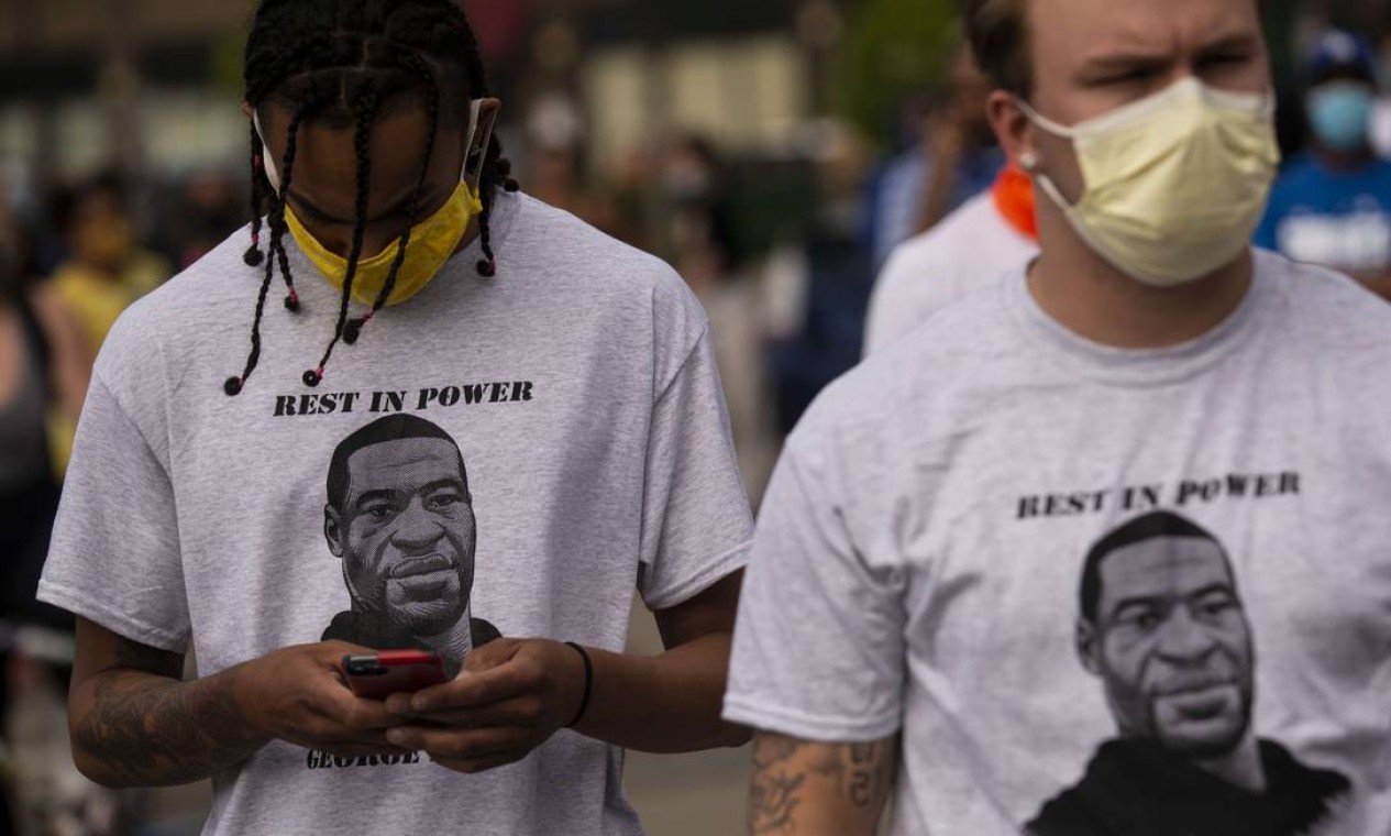 "Descance no poder", um trocadilho com a sigla em inglês RIP ("rest in peace", descanse em paz), em referência ao luto pela morte de George Floyd e ao orgulho negro, é o que diz a mensagem estampada na camisa de dois manifestantes em Mineápolis Foto: Stephen Maturen / AFP