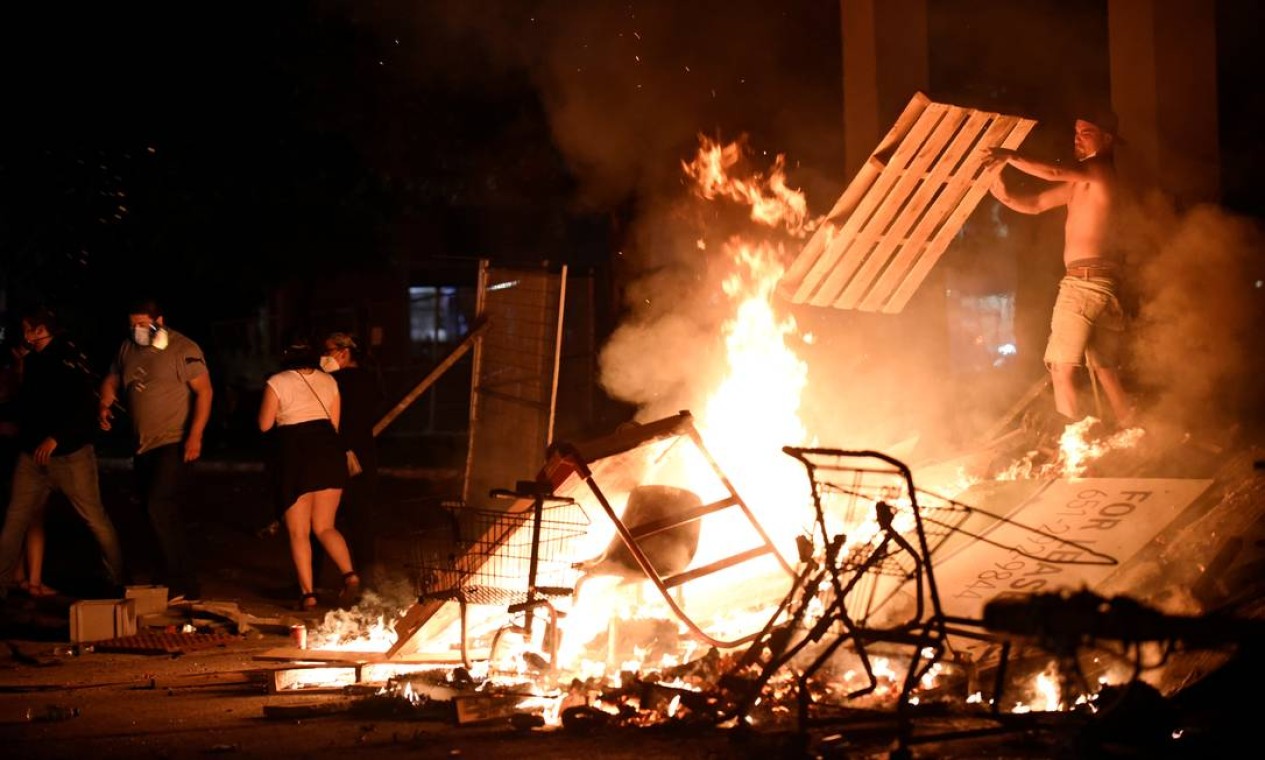 Manifestantes incendeiam barricada com objetos de madeira na 26ª Avenida, próximo ao departamento de polícia onde estão lotados os policiais que mataram George Floyd, em Mineápolis, Minessota, EUA. Os protestos aconteceram durante toda a quarta-feira e ficou mais violento durante a noite Foto: NICHOLAS PFOSI / REUTERS