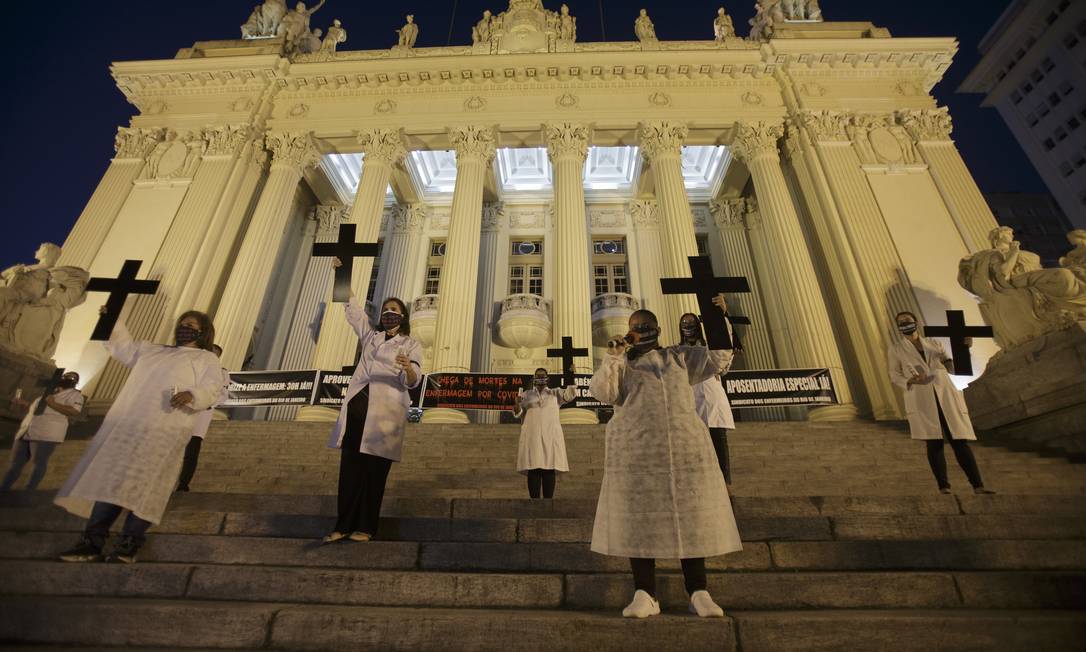 Profissionais de saúde seguram cruzes em referência a colegas mortos, durante um ato em frente à Alerj, no Dia Internacional da Enfermagem em 2020 Foto: Alexandre Cassiano / Agência O Globo - 12/05/2020