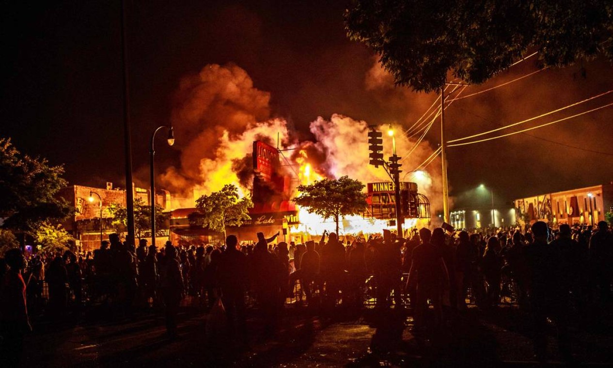 Multidão cerca loja de bebidas incendiada em Minneapolis Foto: KEREM YUCEL / AFP