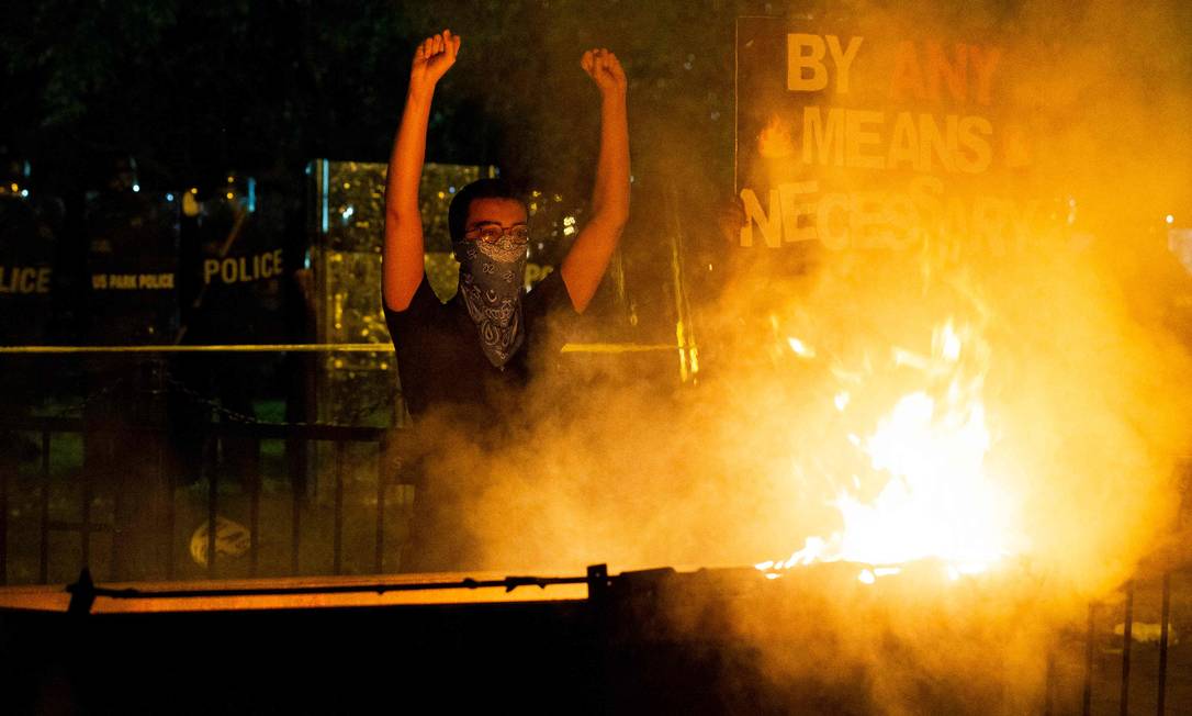 Homem protesta diante da Casa Branca, na noite de sábado Foto: JOSE LUIS MAGANA / AFP