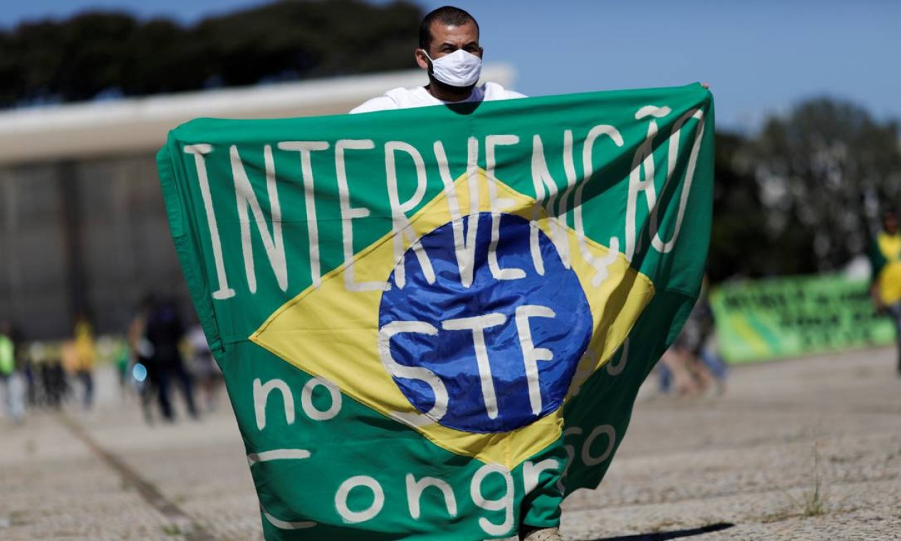 Um apoiador do presidente Jair Bolsonaro segura uma bandeira com a frase "Intervenção no Supremo Tribunal Federal e no Congresso Nacional" durante o protesto em Brasília Foto: UESLEI MARCELINO / REUTERS