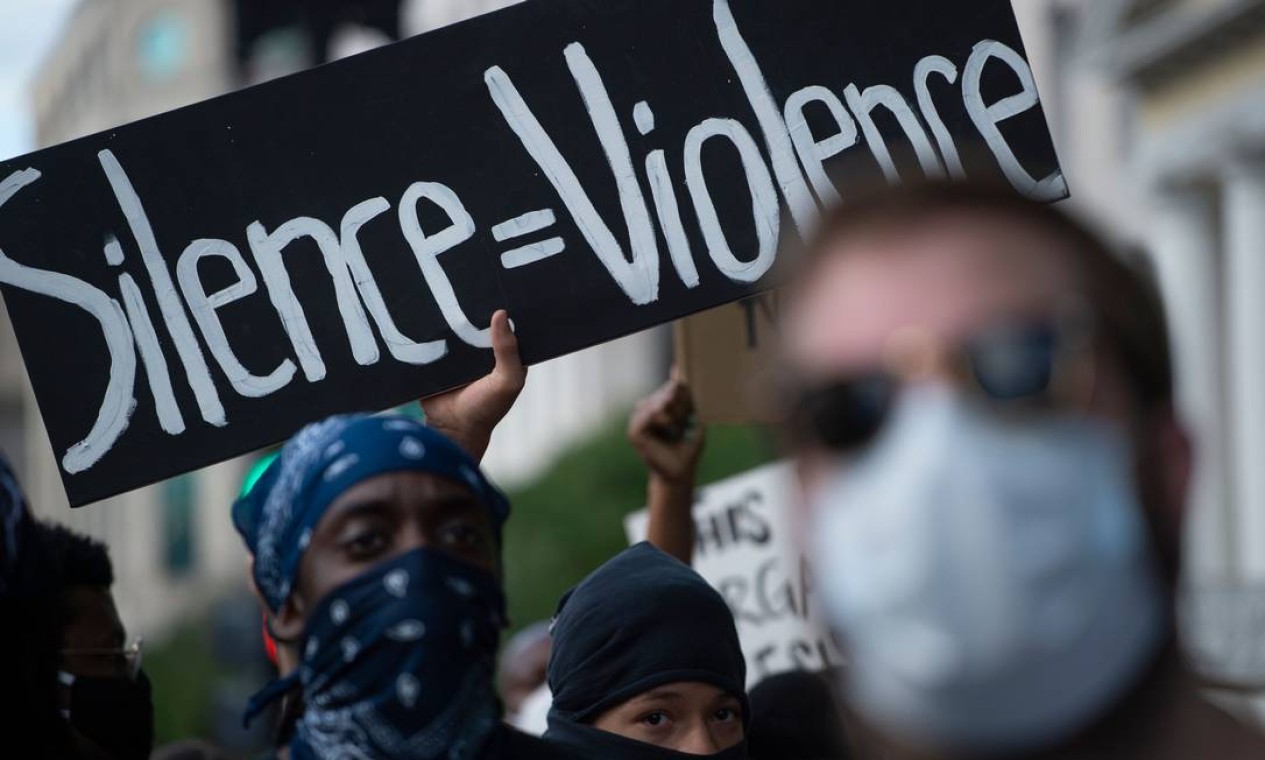 Cartaz diz que silêncio é violência, diante do caso de racismo que envolve o assassinato de George Floyd Foto: ROBERTO SCHMIDT / AFP