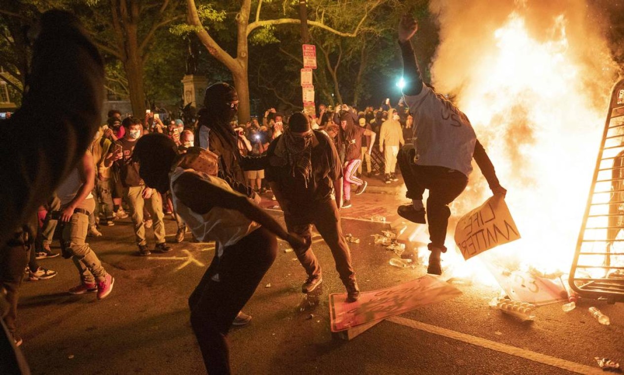 Manifestantes se reúnem perto de fogueira feita próximo a Casa Branca, em Washington Foto: ROBERTO SCHMIDT / AFP