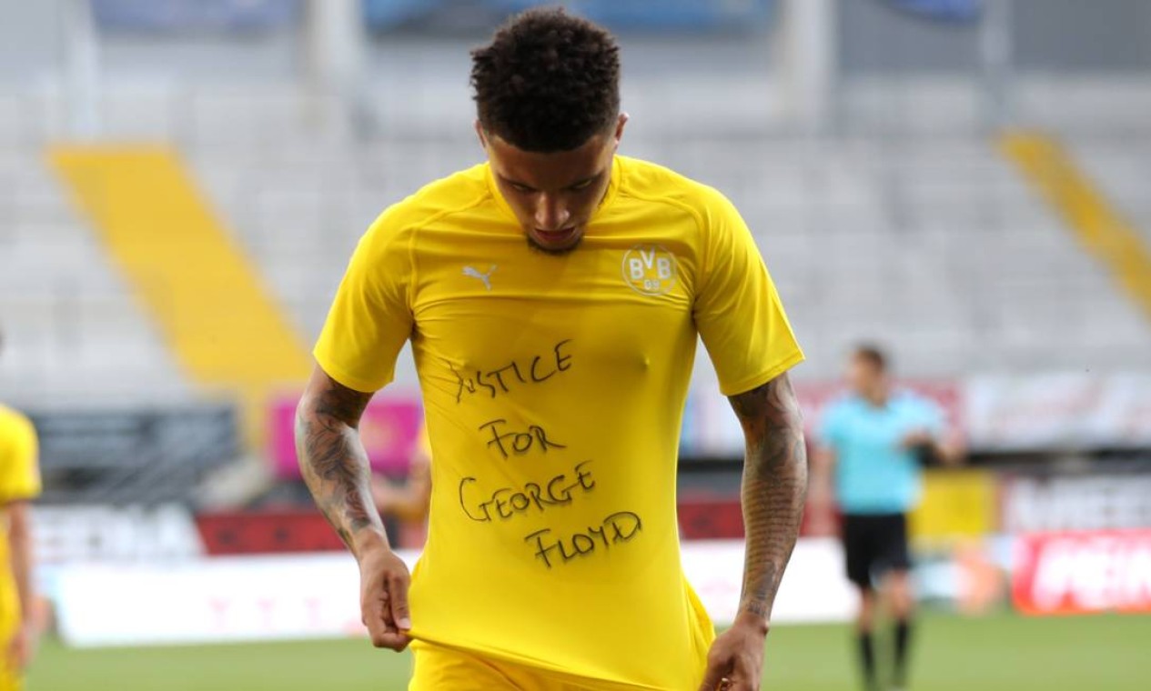 O atacante inglês Jadon Sancho, do Borussia Dortmund, homenageou Gergoe Floyd exibindo mensagem que pedia justiça pelo seu assassinato, após marcar um gol para sua equipe contra o Paderbon, neste domingo, pelo Campeonato Alemão Foto: LARS BARON / AFP - 31/05/2020