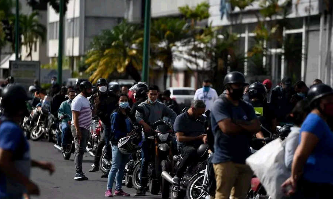 Pessoas fazem fila em postos de gasolina para reabastecer motos em Caracas, em 1 de junho de 2020, primeiro dia de venda de gasolina em dólares Foto: Federico Parra / AFP